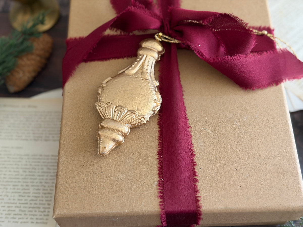 Baubles Mould (2026 Limited Release) by I.O.D.—vintage-style glass baubles with red ribbon on book pages.