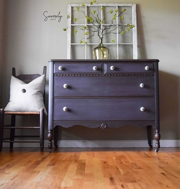 Dark dresser painted with Old Fashioned Milk Paint’s Adelaide, vase with green branches on top, next to a chair.