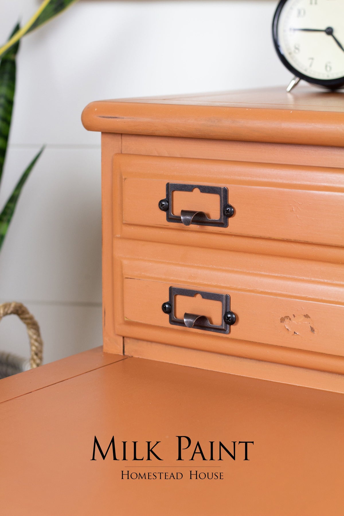 Orange wooden desk with black metal handles, clock on top; finished in Autumn Leaves Milk Paint by Homestead House.
