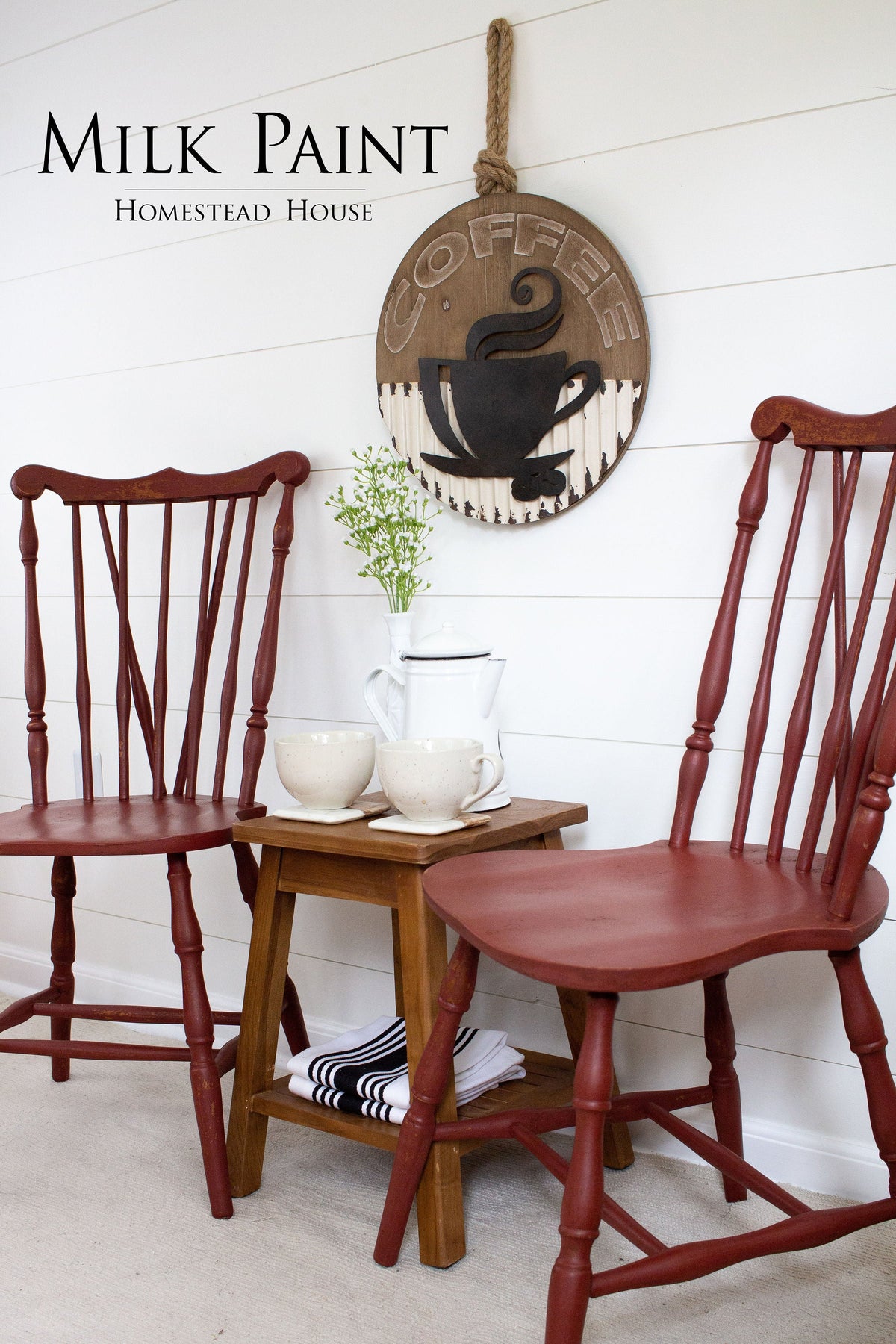 Two Homestead House Barn Red Milk Paint chairs beside a table; coffee sign on white shiplap wall in background.