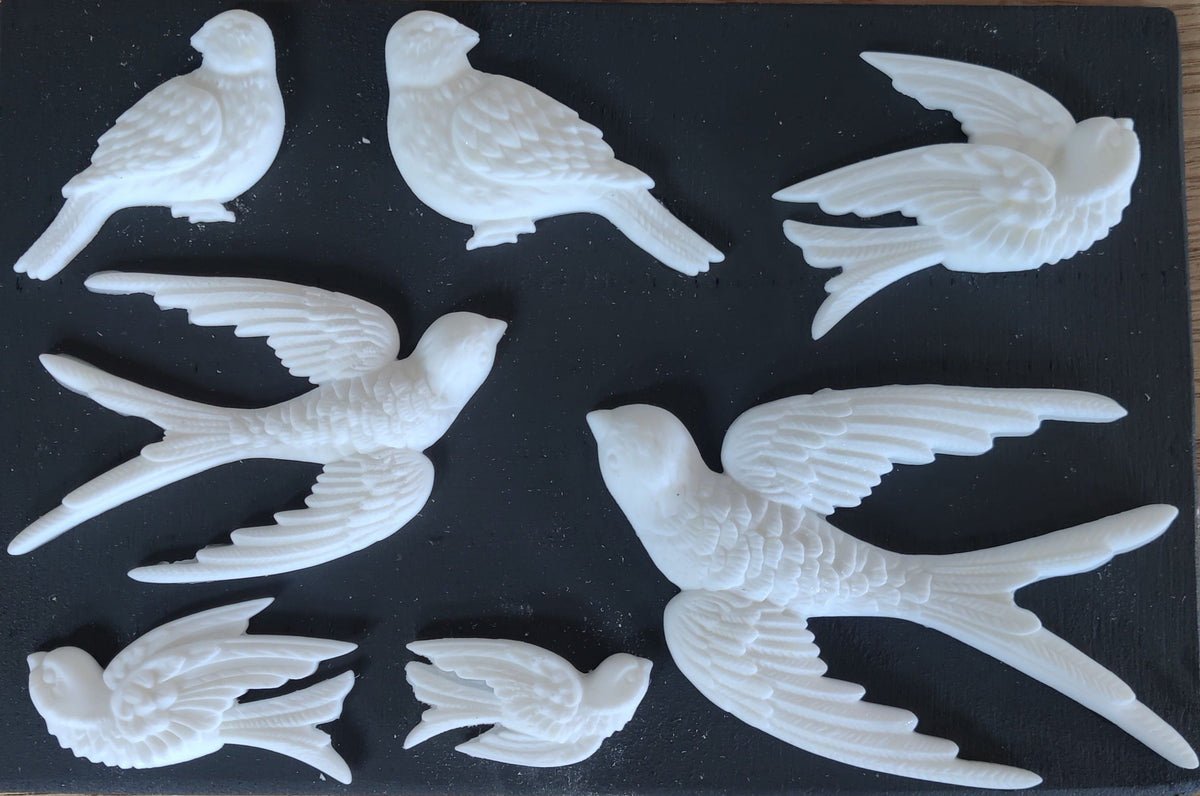Seven white Birdsong Mould by I.O.D. birds displayed in flying and perched arrangements.