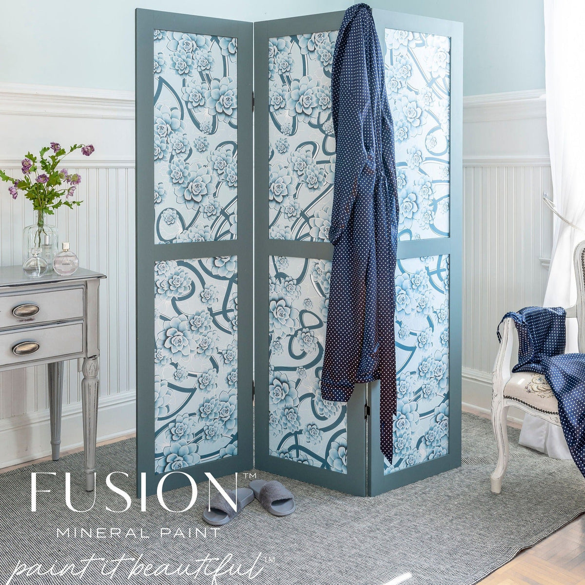 Blue floral folding screen in Fusion Mineral Paint Blue Pine, positioned beside a desk with a robe and slippers nearby.