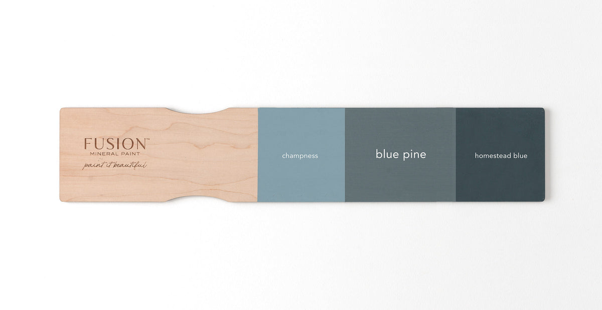 Fusion Mineral Paint swatches: Champlain, Blue Pine, and Homestead Blue displayed on a wooden board.