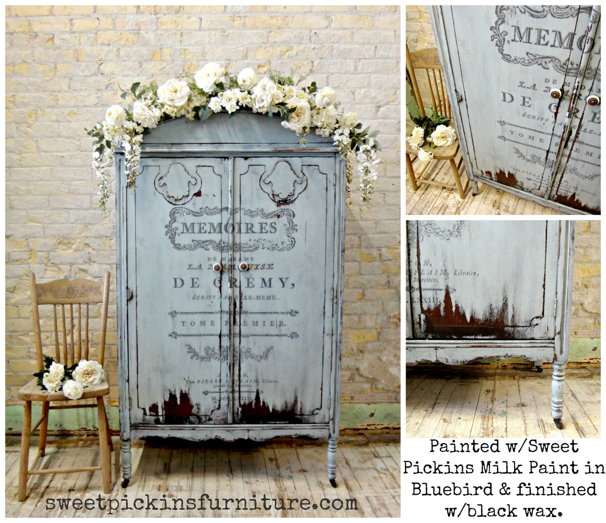 Bluebird armoire painted with Old Fashioned Milk Paint, black script, floral garland, and distressed edges.