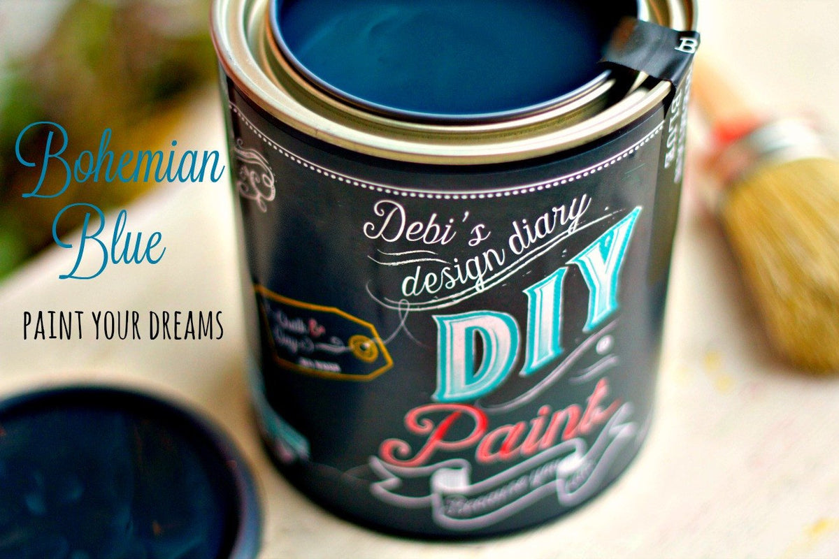 Open can of DIY Paint Co. Bohemian Blue with its lid and a paintbrush nearby.