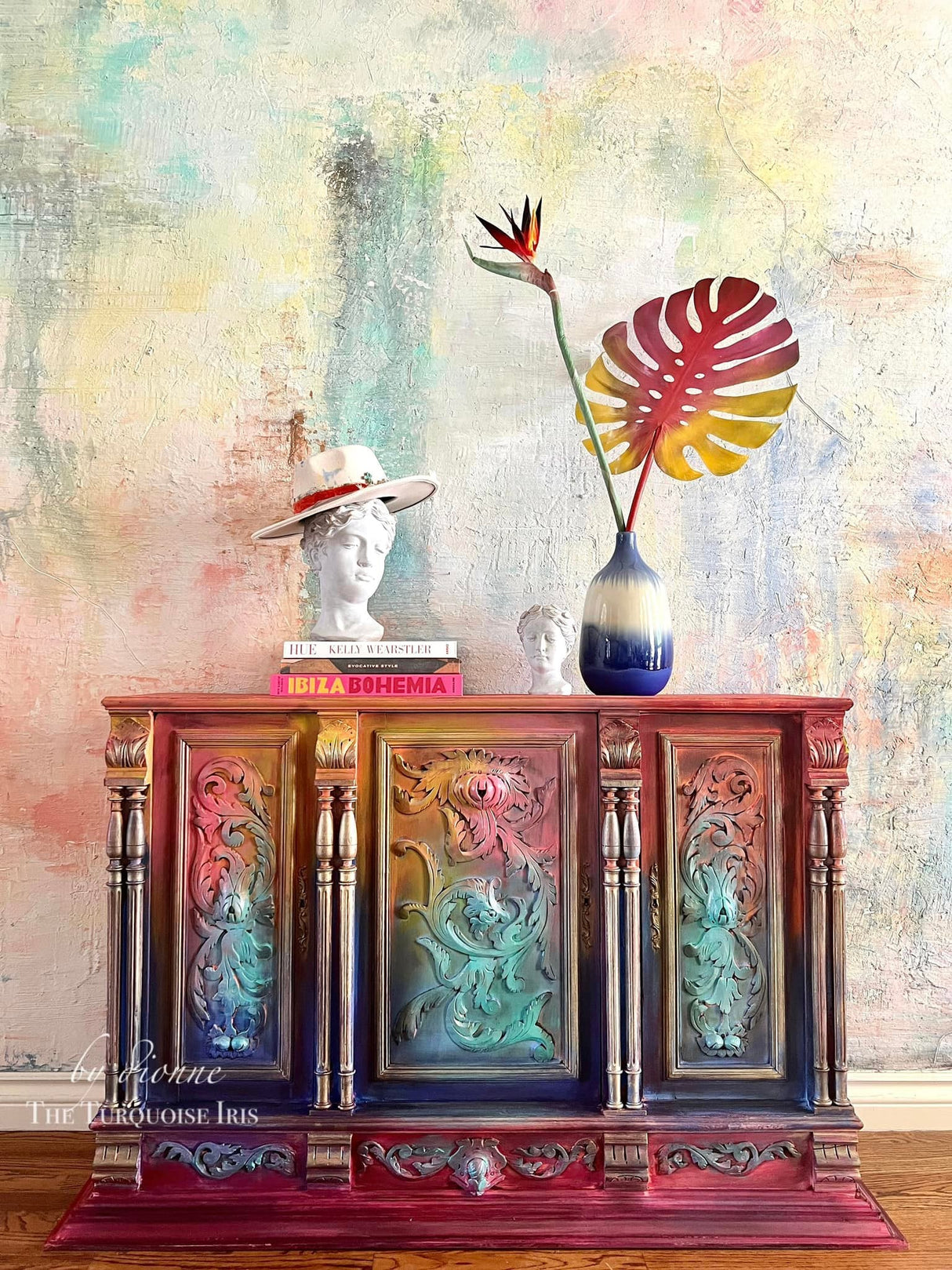 Bohemian Brights by DIY Paint Co. painted furniture with books, busts, and tropical foliage against a pastel wall.
