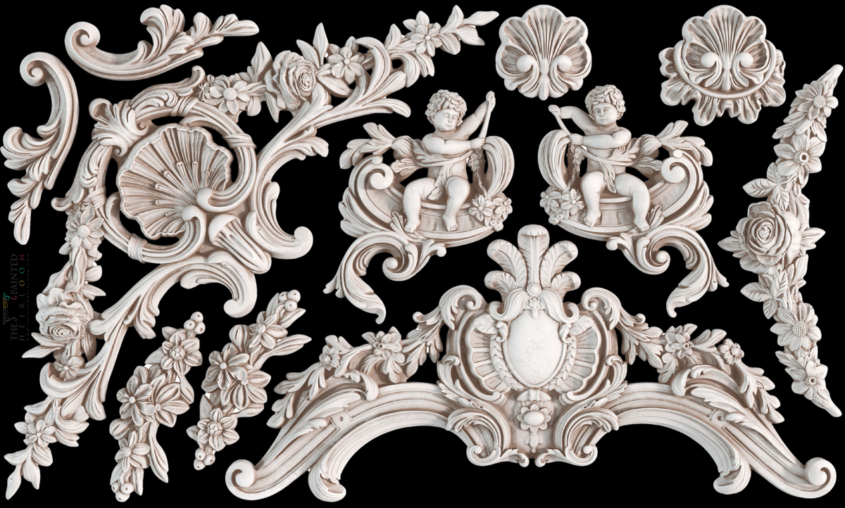 White cherubs and carvings made with I.O.D. Cadré Mould by Iron Orchid Designs on a black background.