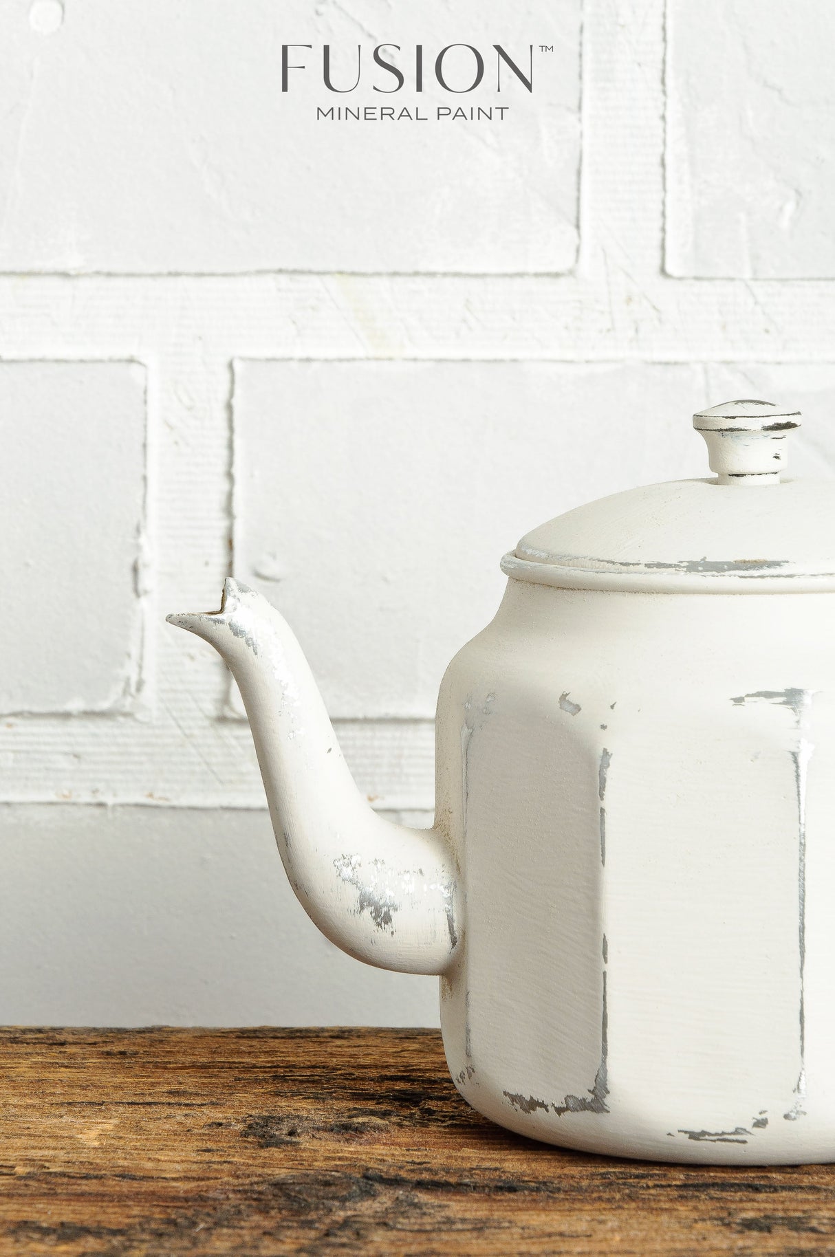 White teapot painted with Champlain Fusion Mineral Paint displayed on a wooden surface.