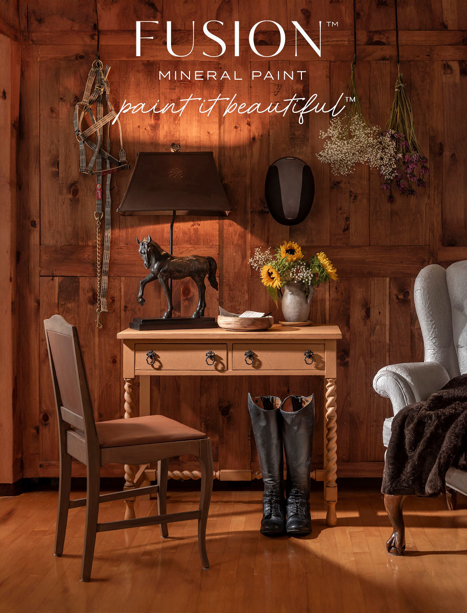 Wooden table with lamp, horse statue, and flowers against wall painted in Chestnut Mare Fusion Mineral Paint.
