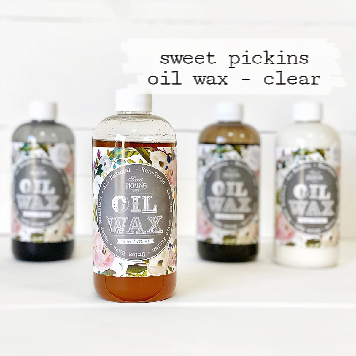 Four Sweet Pickins Clear Oil Wax bottles from Old Fashioned Milk Paint, with the clear bottle in the center.