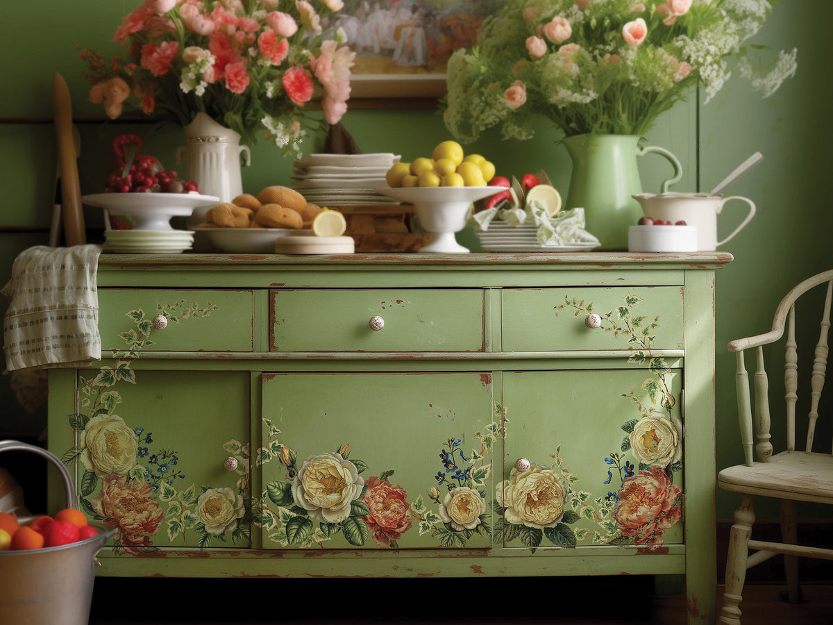 Green vintage cabinet with I.O.D.’s Collage De Fleurs Transfer, topped with fruit, pastries, and kitchenware.