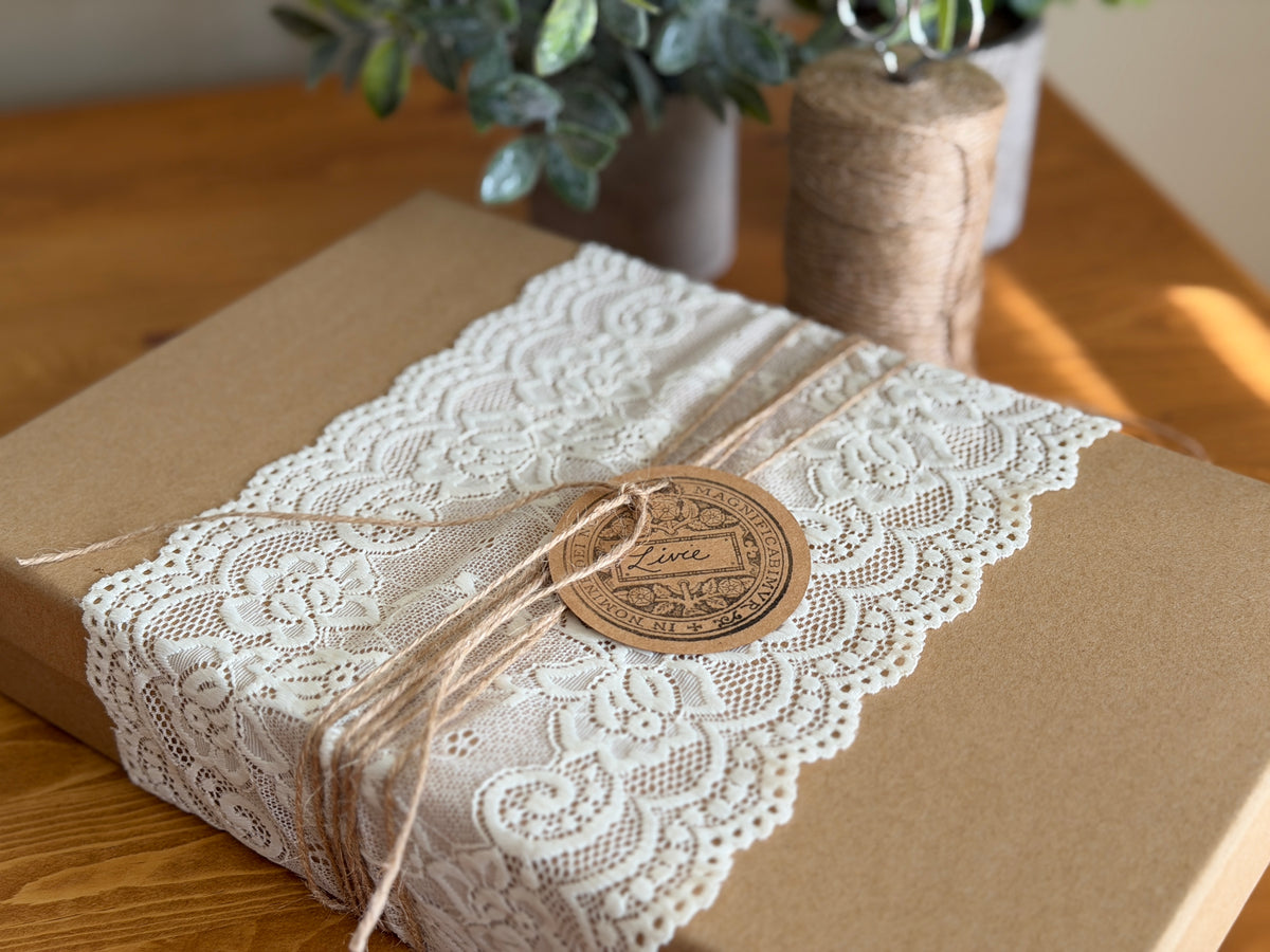 Brown gift box with white lace, twine, and I.O.D. Emblems Mini-Stamp tag.