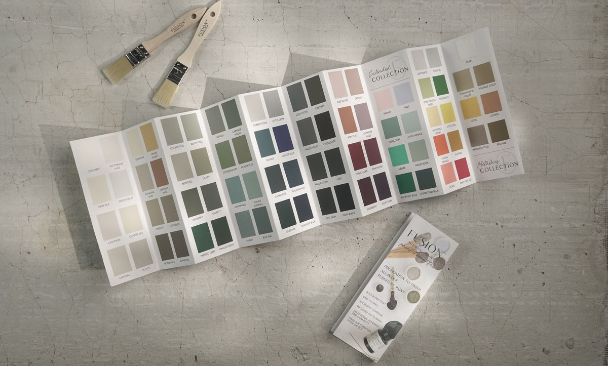 Fusion Mineral Paint True to Color Card 2024, paintbrushes, and brochure on a textured surface.