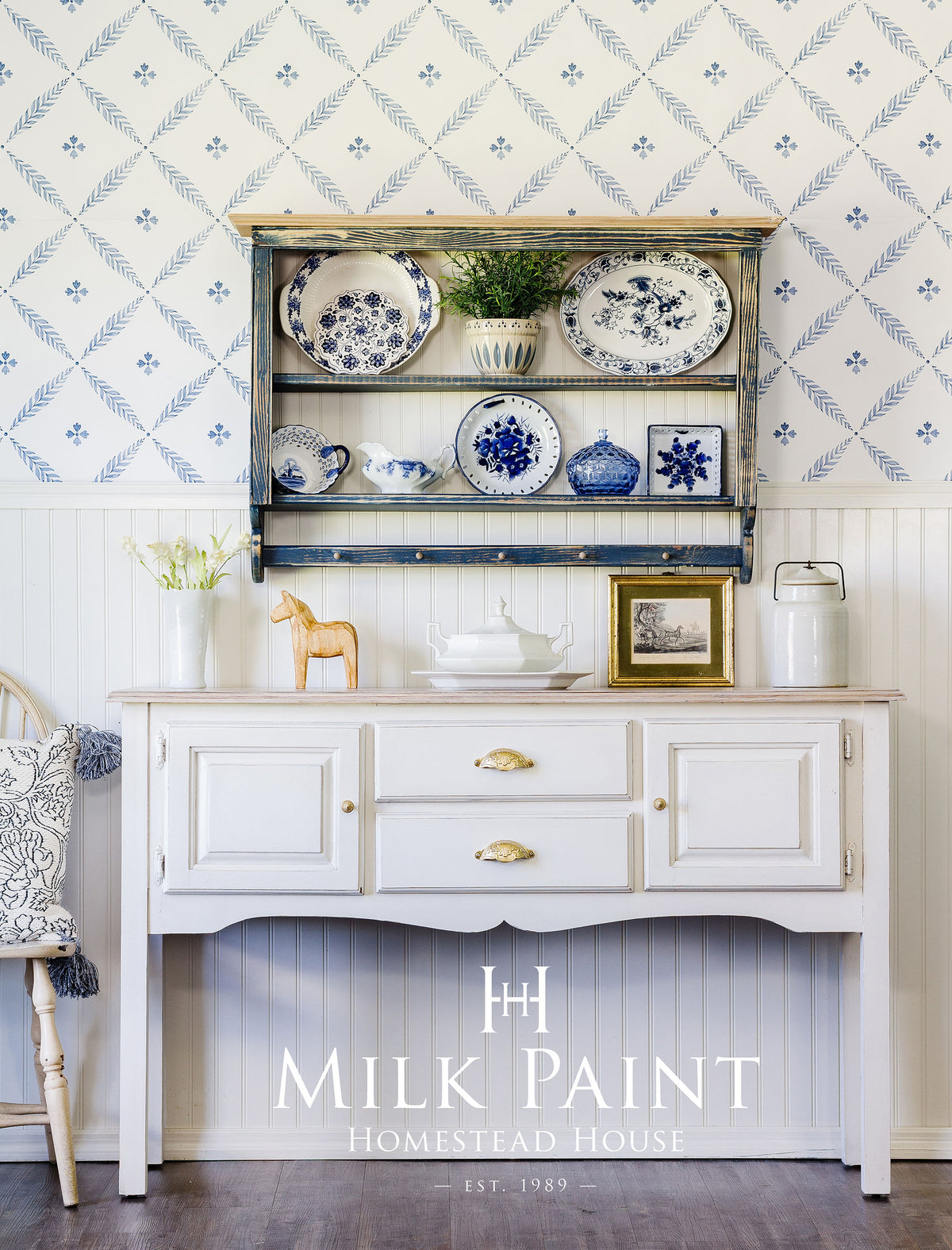 Homestead House sideboard in Gustavian White Milk Paint with gold handles and blue plates on top.