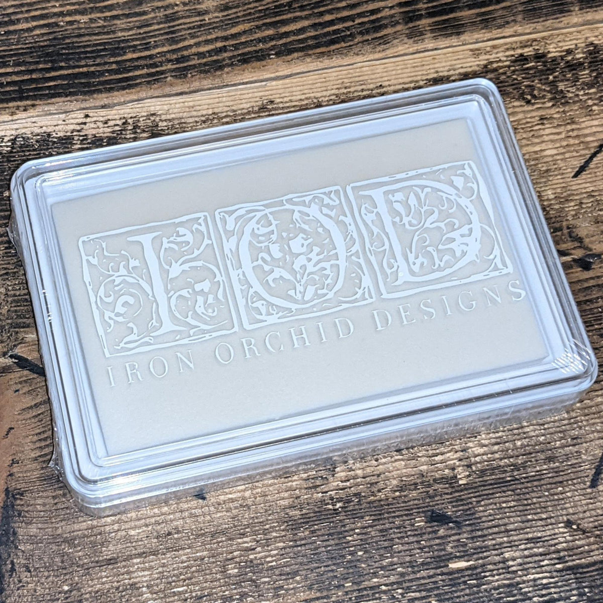 IOD Ink Pad (Uninked) by Iron Orchid Designs on a wooden surface, for use with IOD stamps.