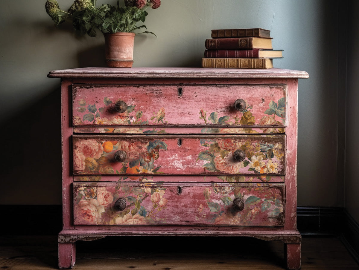 Pink dresser with I.O.D. Joie Des Roses rose motif, books, and plant displayed on top.