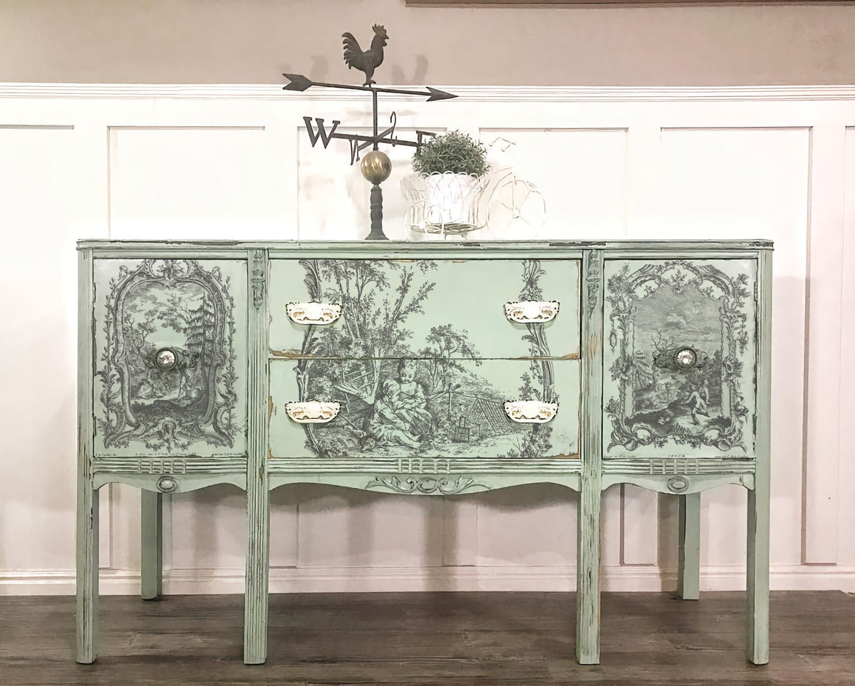 Mint green vintage sideboard with I.O.D. La Chasse Paint Inlay, ornate black designs, white pulls, and rooster weathervane.