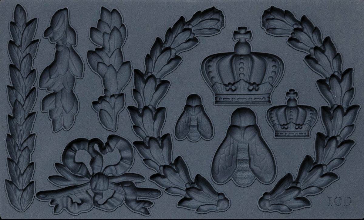Laurel Mould by I.O.D. with crown, bee, ribbon, and laurel leaf motifs in a dark matte finish.