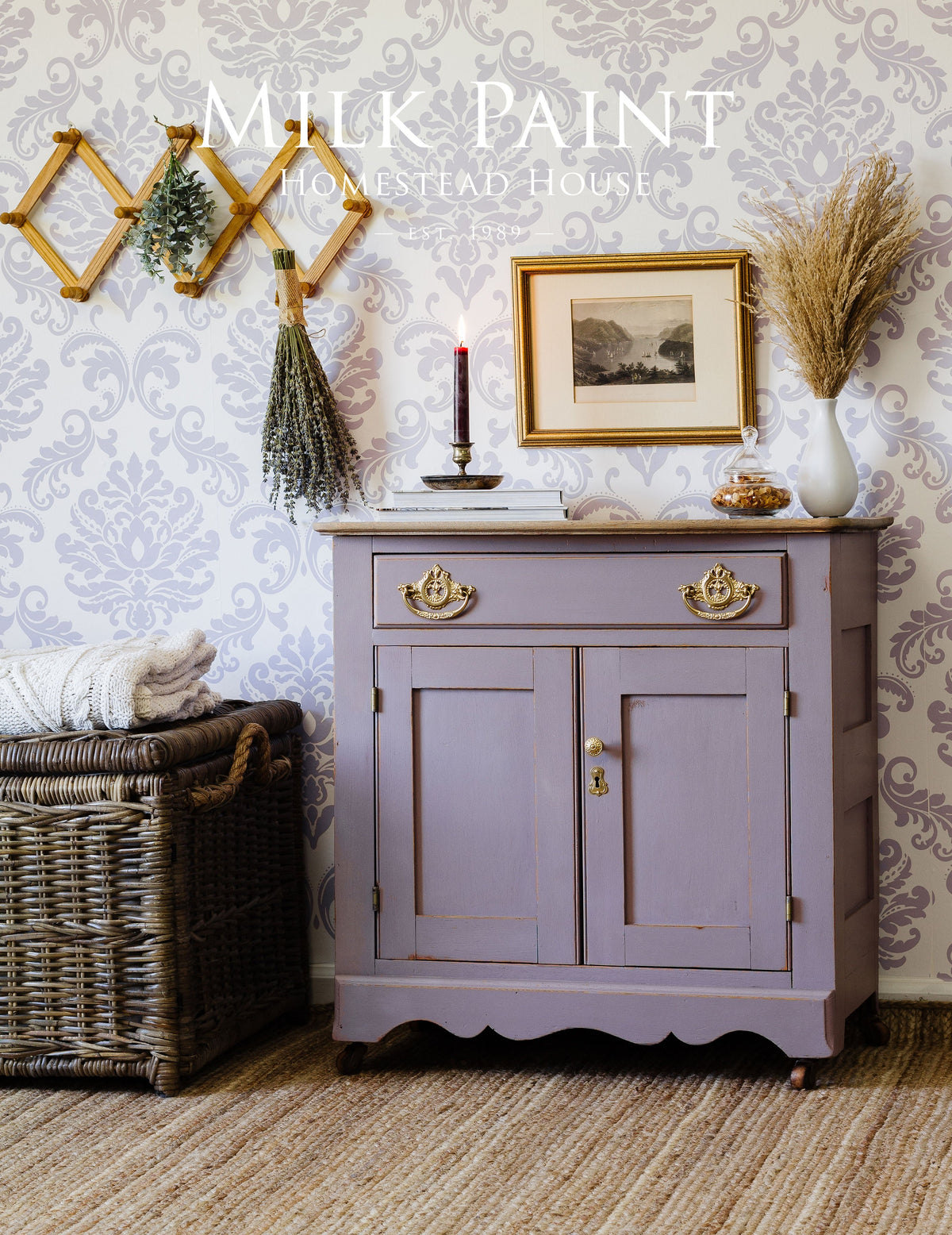Cabinet in Lavande Milk Paint by Homestead House with gold handles and decorative baskets styled nearby.