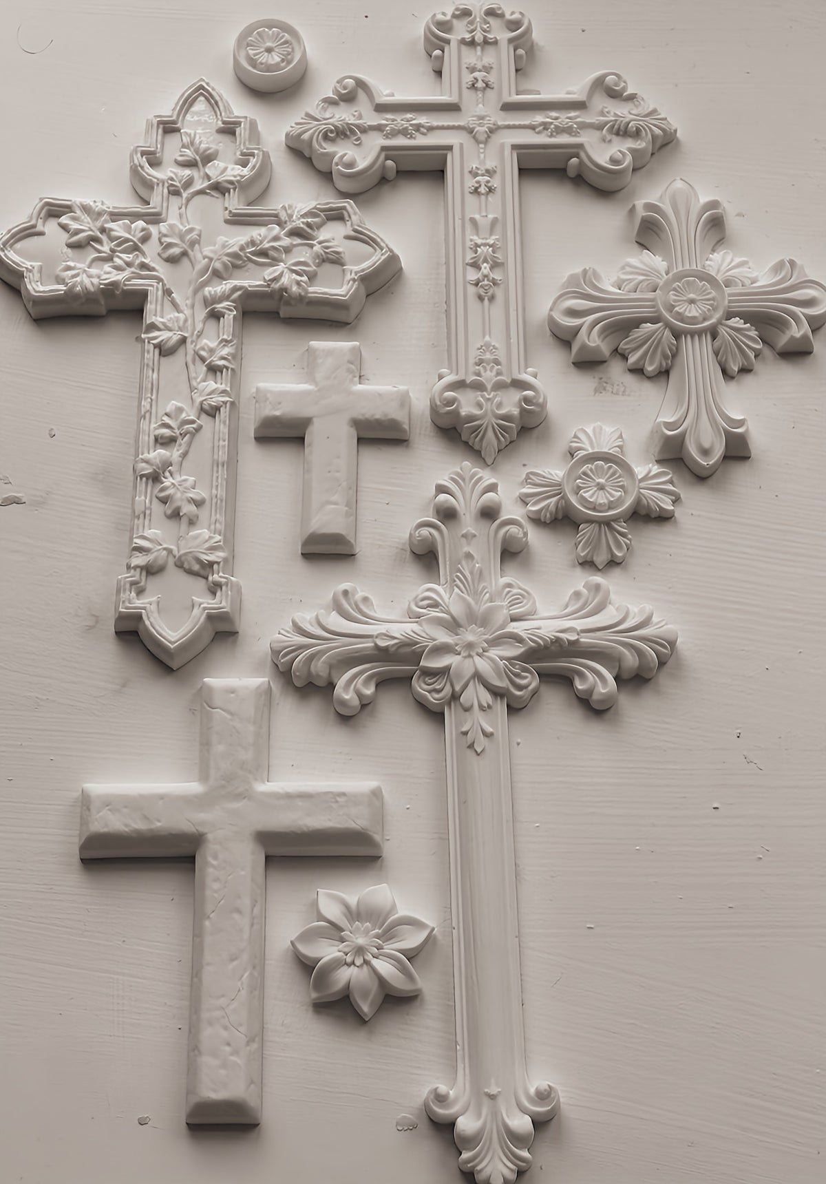Seven white crosses, two floral medallions, and one flower crafted with the Les Croix Mould by I.O.D.