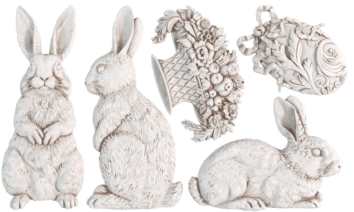 Les Lapins Mould by IOD: five white carvings featuring rabbits, a flower basket, and an ornate egg shape.