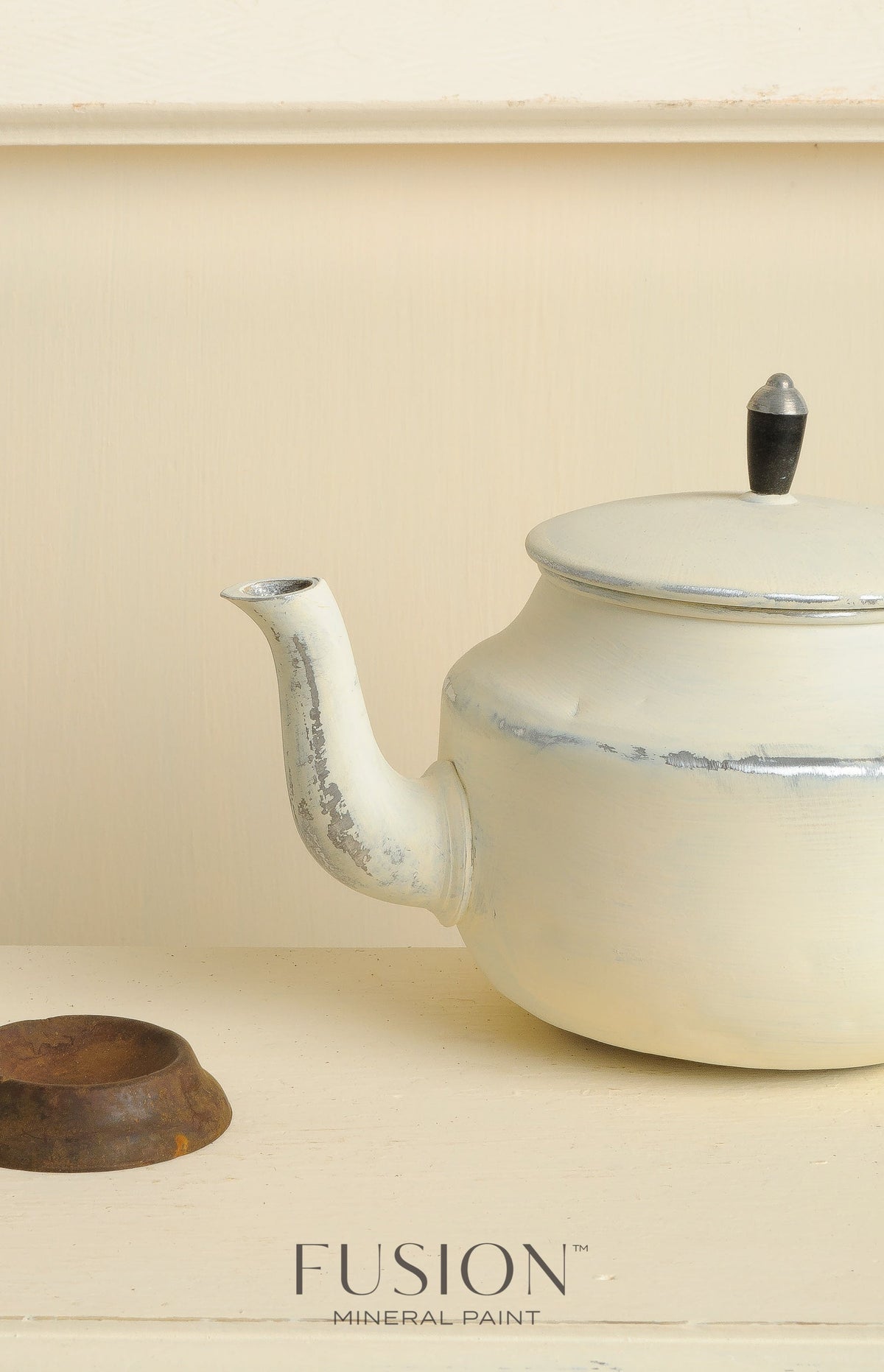 Teapot painted with Limestone Fusion Mineral Paint on a cream shelf next to a small rusted metal ring.