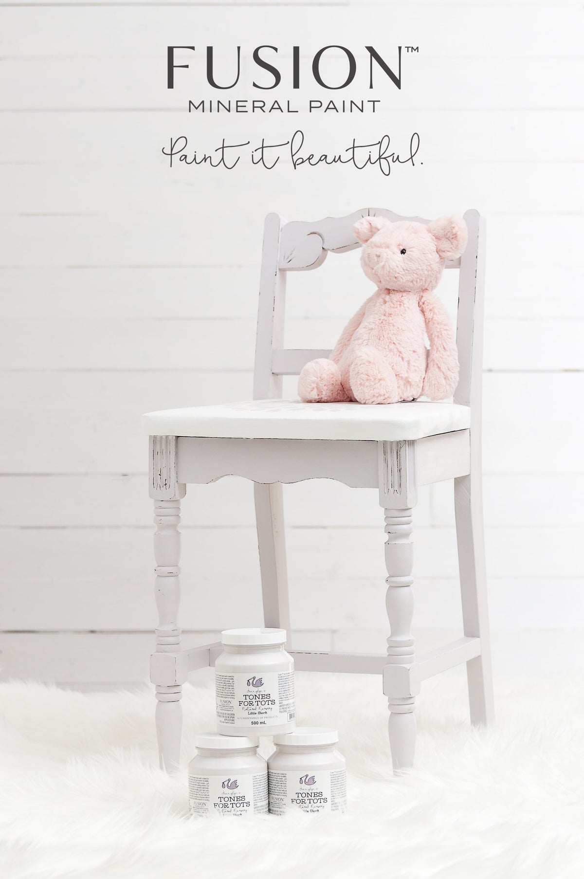 Light gray chair with a pink plush pig and three Little Stork Fusion Mineral Paint jars on a white fur rug.