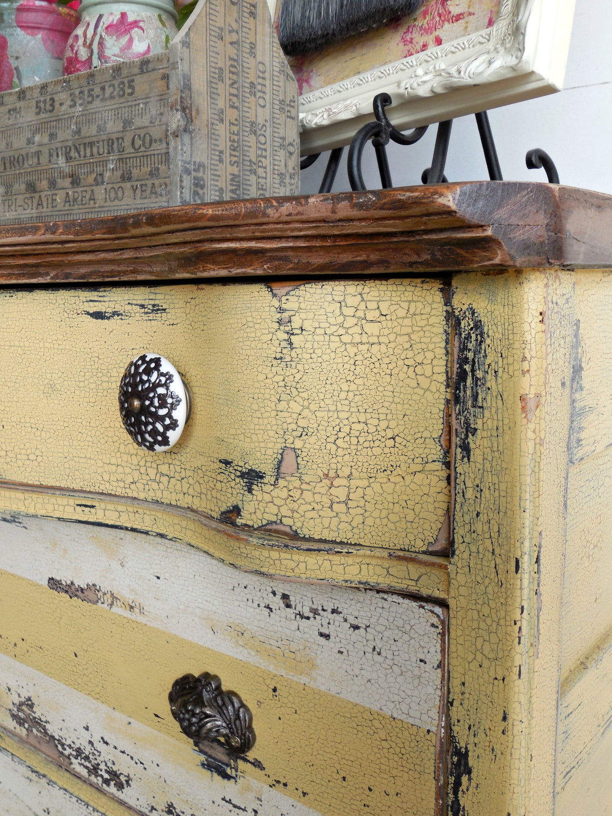 Distressed yellow dresser in Love Bug by Old Fashioned Milk Paint, featuring vintage drawer handles.