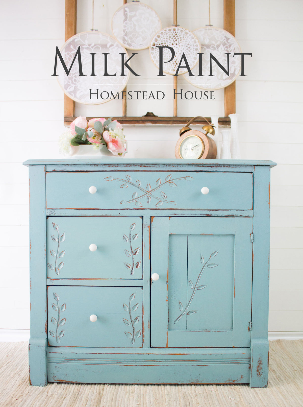 Blue cabinet with white knobs and floral carvings, painted in Homestead House Loyalist Milk Paint.