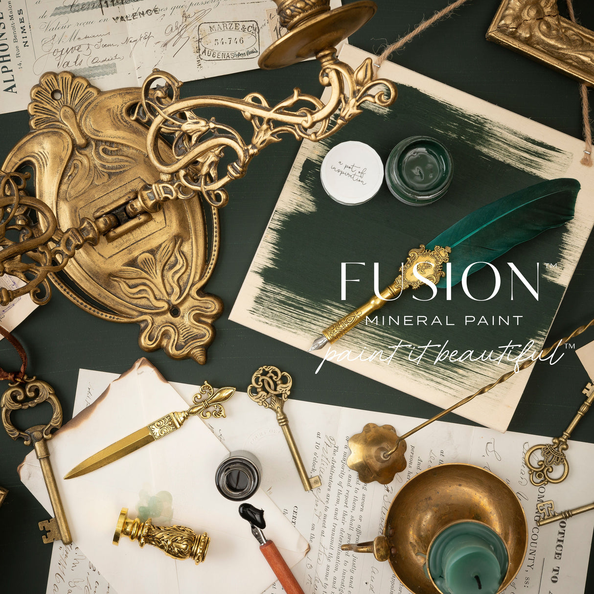 Antique keys, feather quill, Fusion’s Manor Green paint pots, and vintage documents arranged on a flat surface.