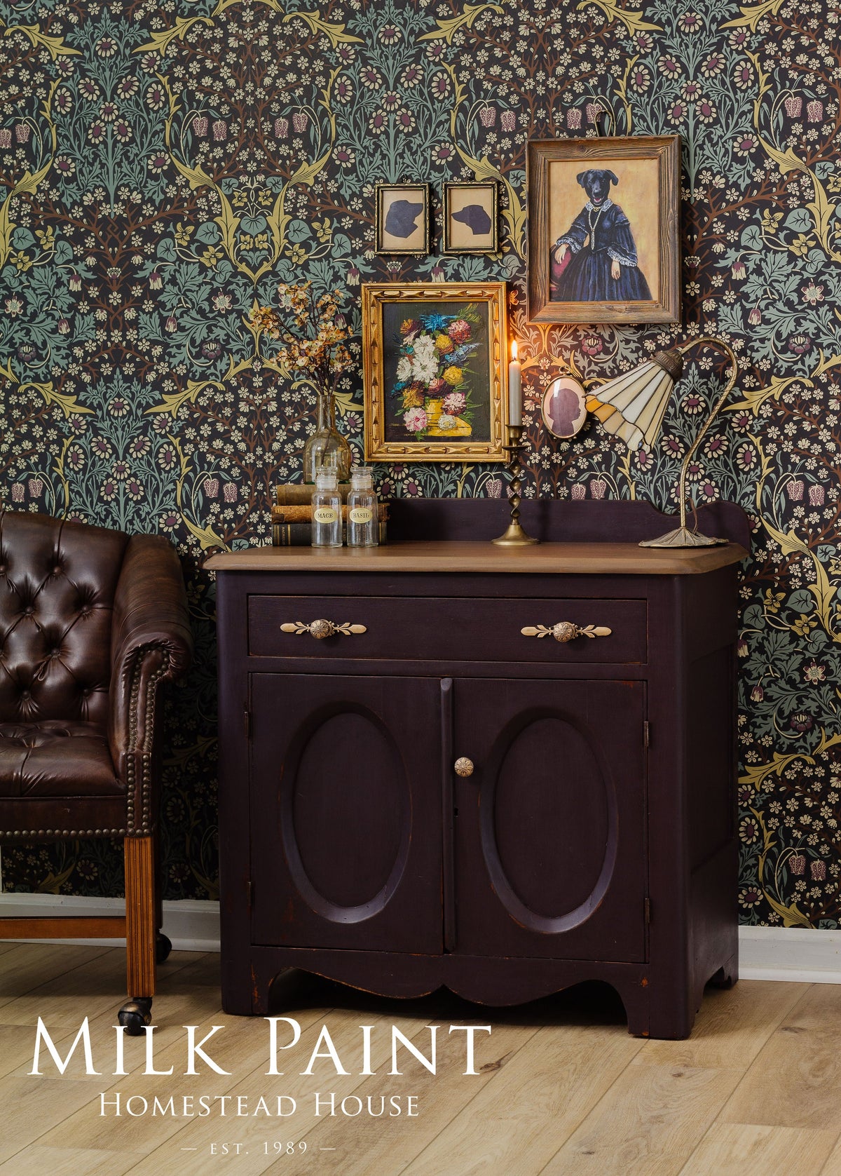 Dark wood cabinet in Homestead House Mennonite Red Milk Paint against floral wallpaper, near a leather chair.