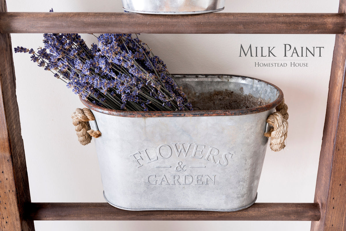Metal bucket with dried lavender on shelf displaying Fusion Mineral Paint’s Milk Paint Wood Stain.