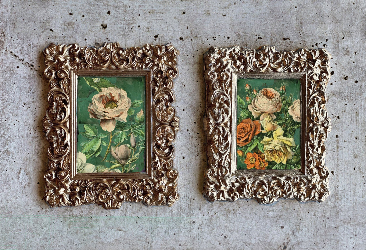Two gold frames with roses using I.O.D. Millot’s Pages Transfer by Iron Orchid Designs on a gray wall.