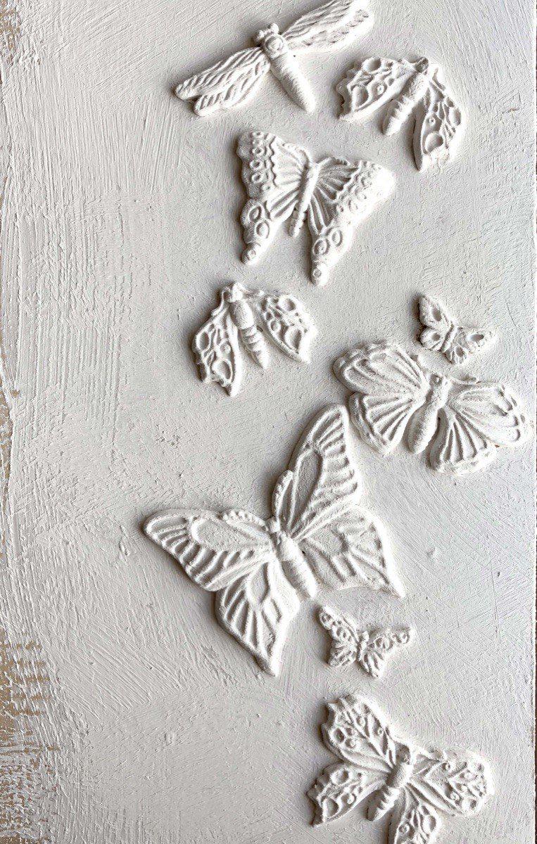 Embossed butterflies and moths created with Monarch Mould by IOD on a textured white background.