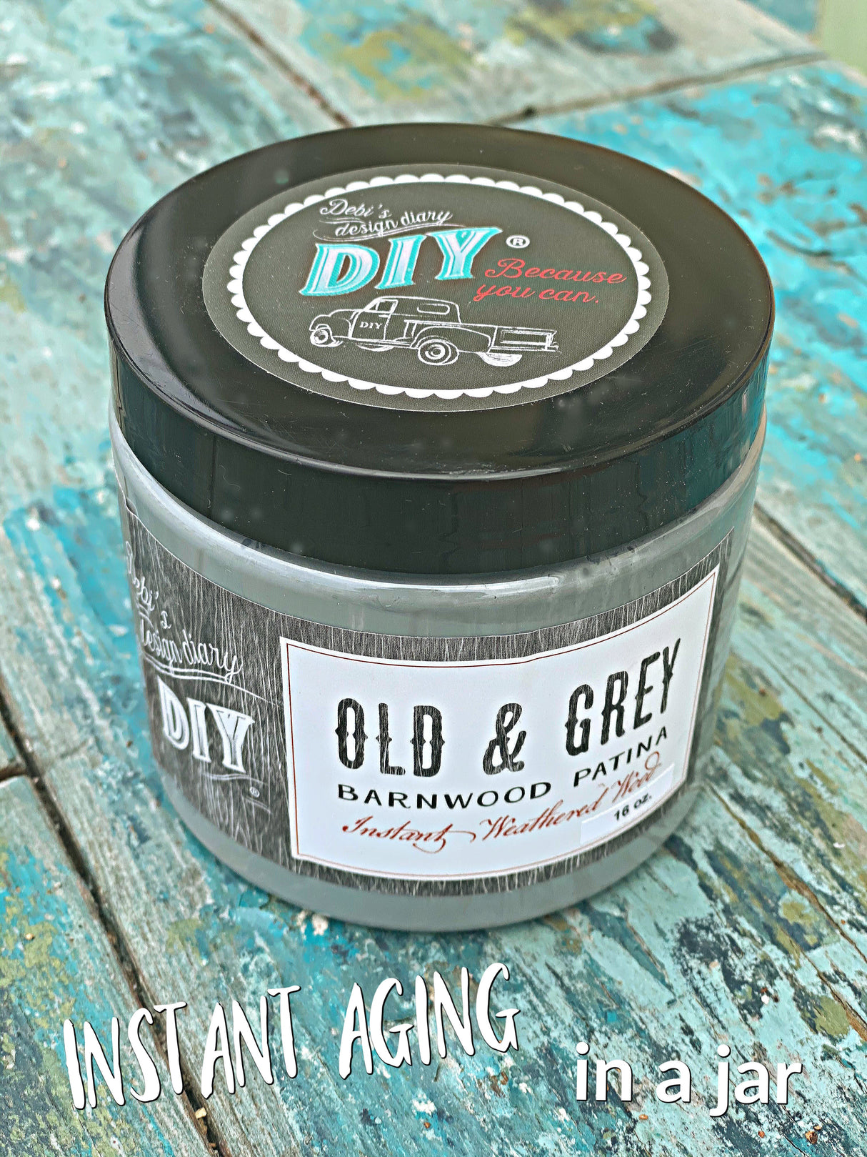 DIY Paint Co. Old & Grey Barnwood Liquid Patina jar on blue wooden surface.