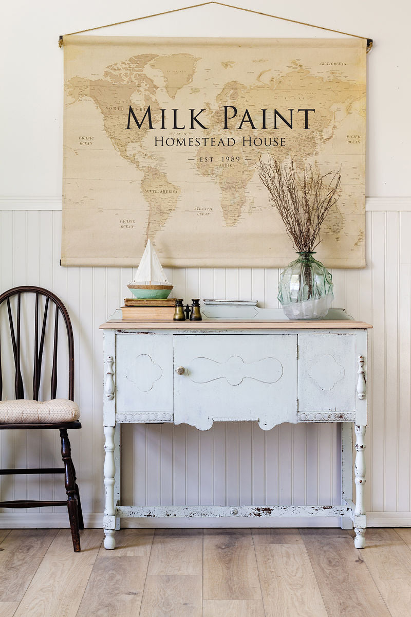 Side table finished in Parlour Milk Paint by Homestead House, shown beside a chair on wood floors.