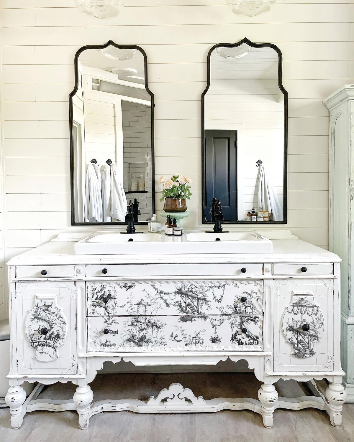 White vintage vanity with IOD Petits Parasols inlays, dual sinks, mirrors, and black fixtures.