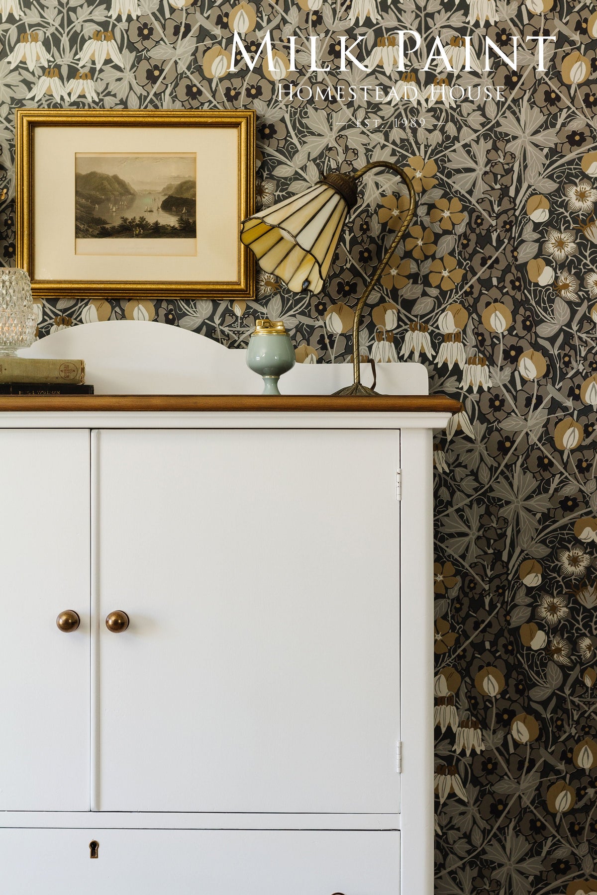 White cabinet finished in Homestead House Porcelain Milk Paint, shown with a lamp and picture on top.