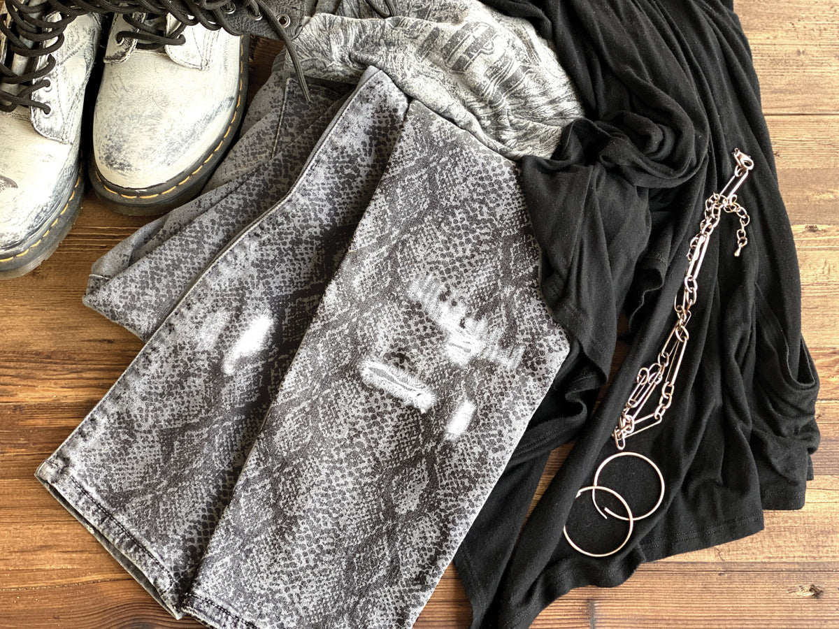 White boots, snake print jeans, black top, styled with I.O.D. Serpentine Stamp flair and silver accessories.