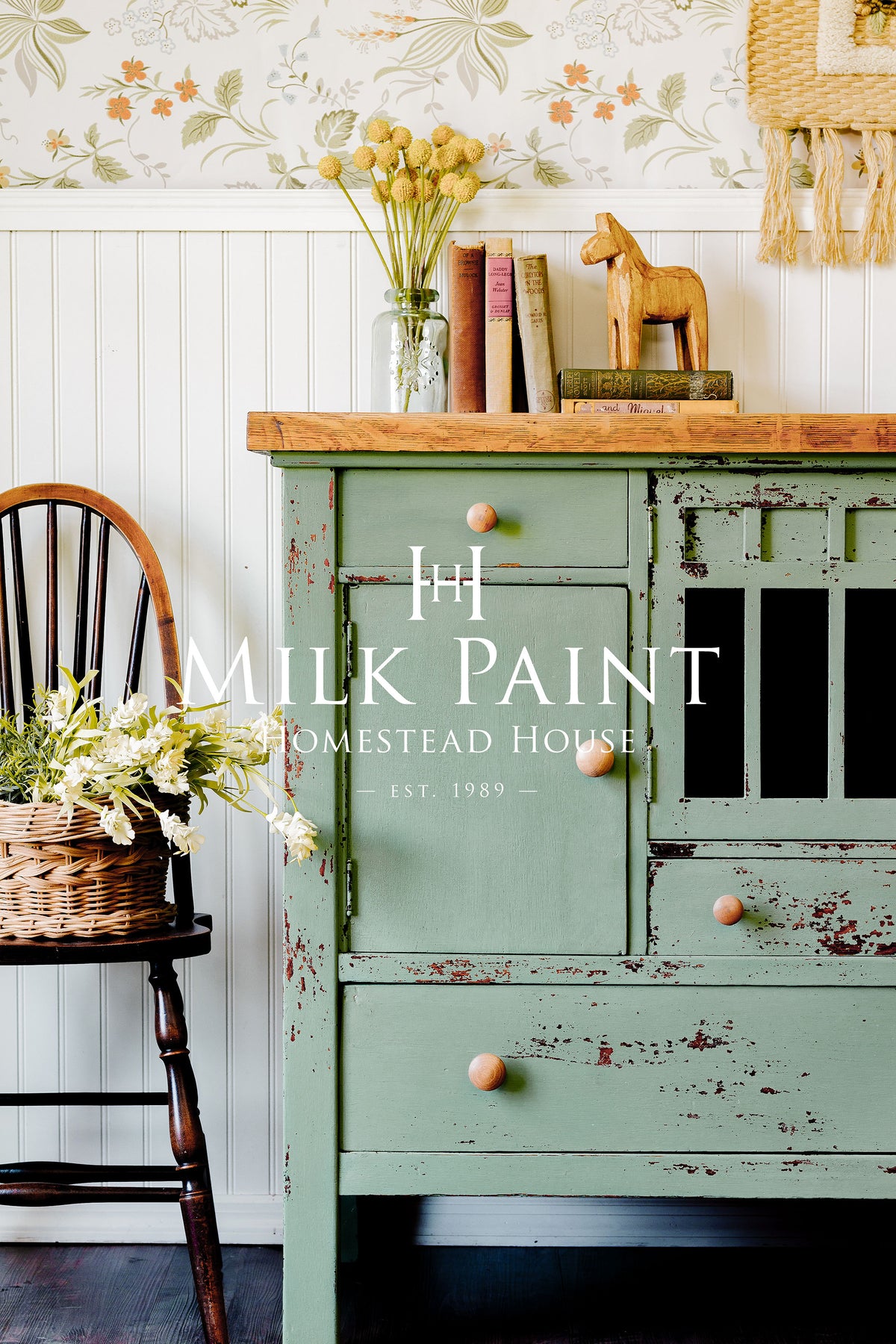 Vintage cabinet painted in Stockholm Green Milk Paint by Homestead House next to a floral chair.