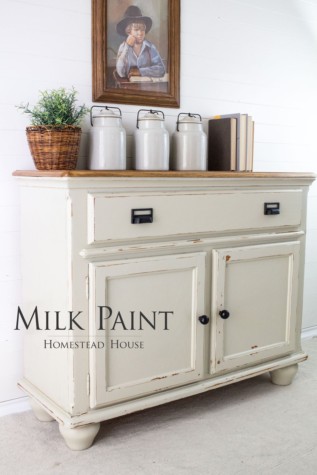 Sideboard painted with Homestead House Stone Fence Milk Paint, holding jars and books, portrait displayed above.