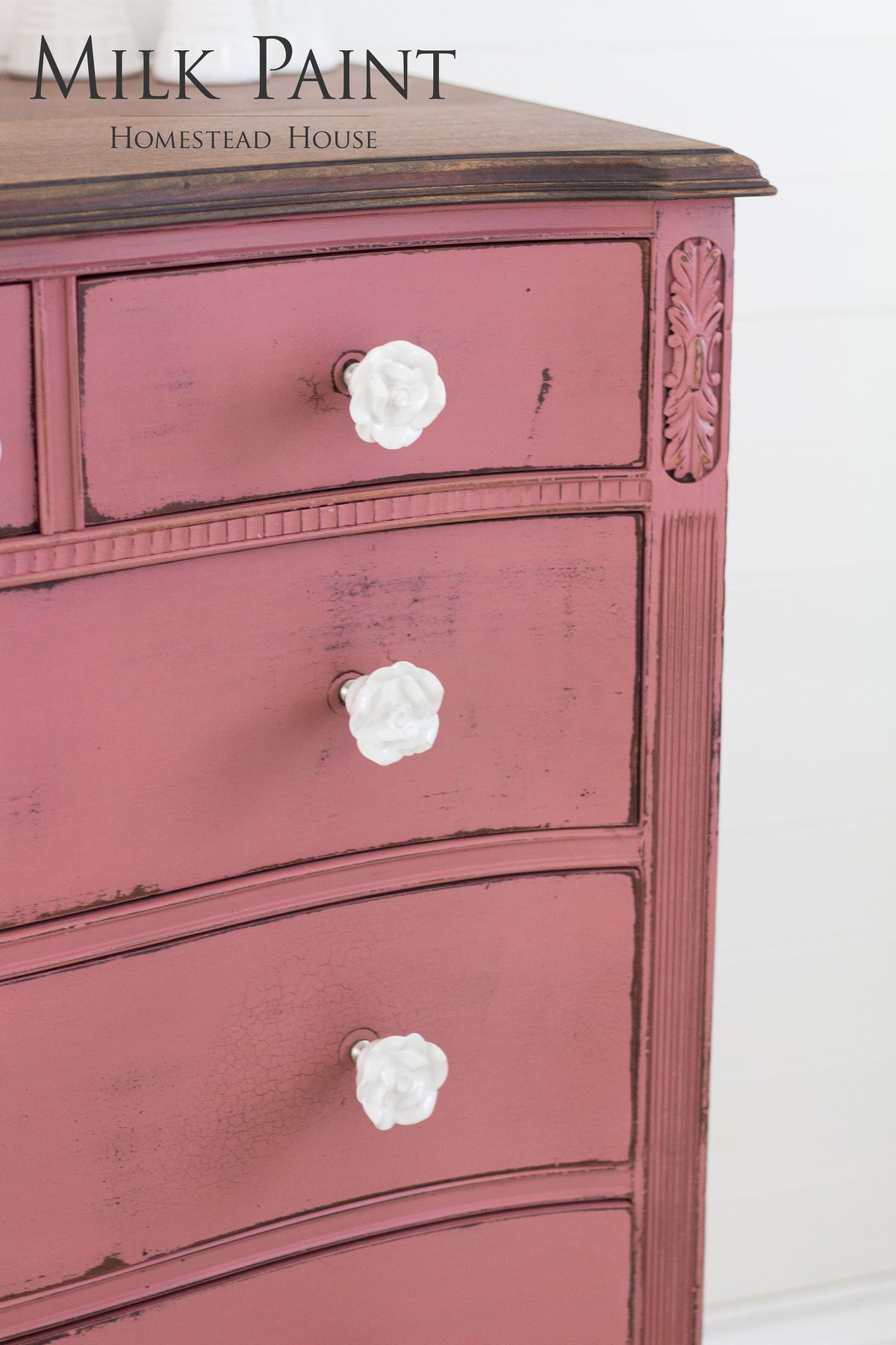 Distressed dresser in Texas Rose Milk Paint with three white flower knobs and visible wood grain.
