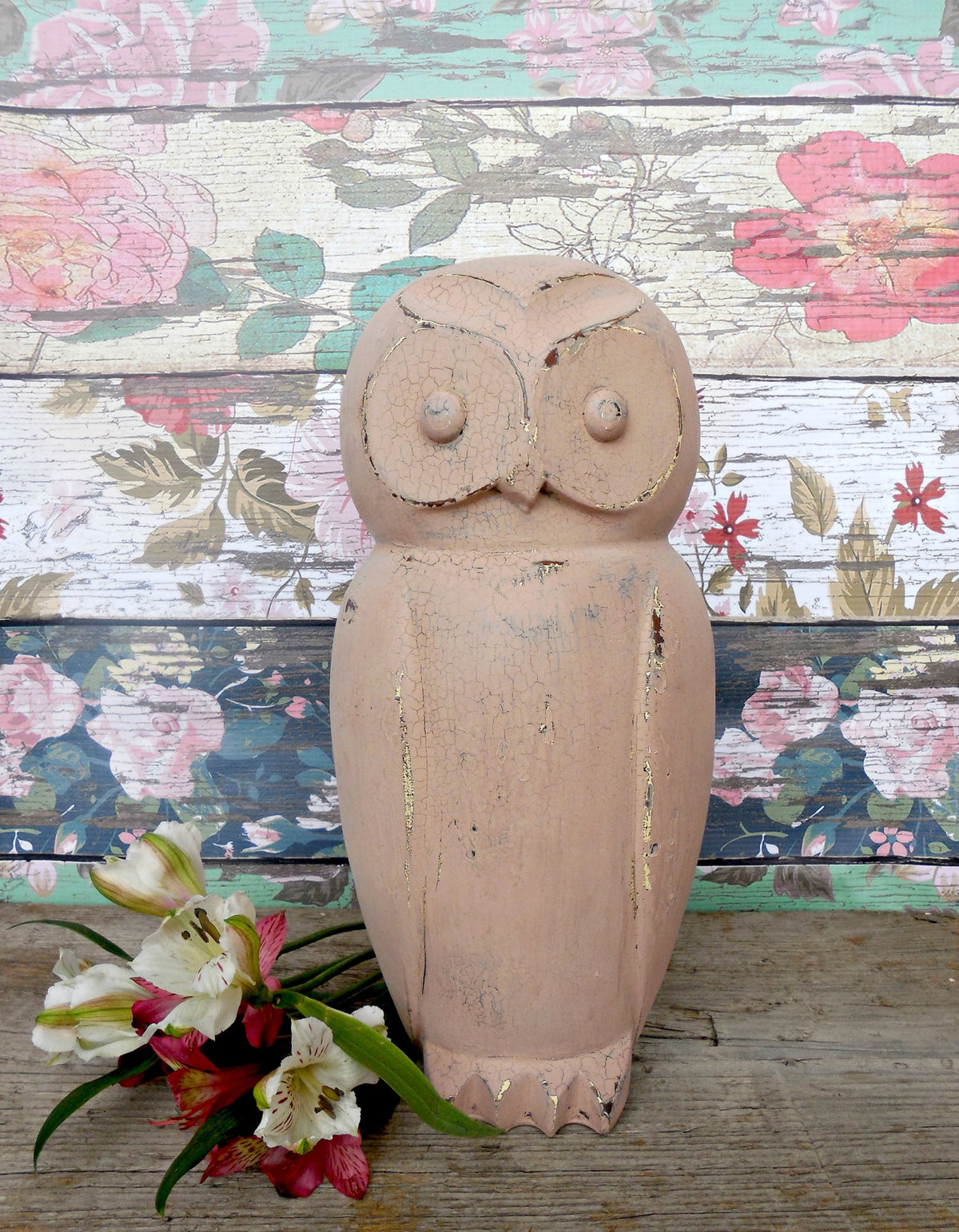 Wooden owl sculpture with cracked finish by flowers, set before Tickled Pink floral wall by Old Fashioned Milk Paint.
