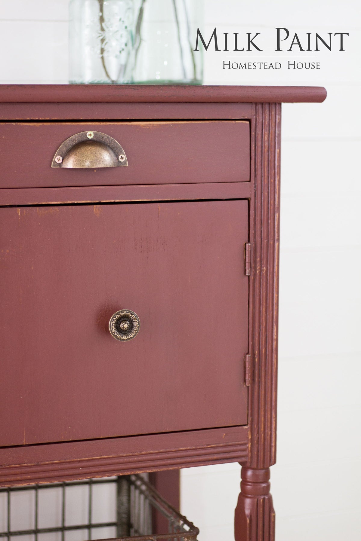 Wooden cabinet in Trading Post Red Milk Paint by Homestead House with metal knobs; “Homestead House” text upper right.