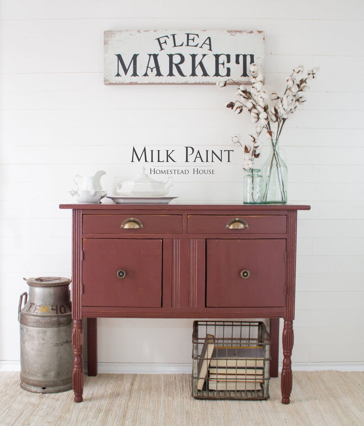 Red sideboard in Homestead House Trading Post Red Milk Paint with white dishes, cotton bouquet, and old milk can.