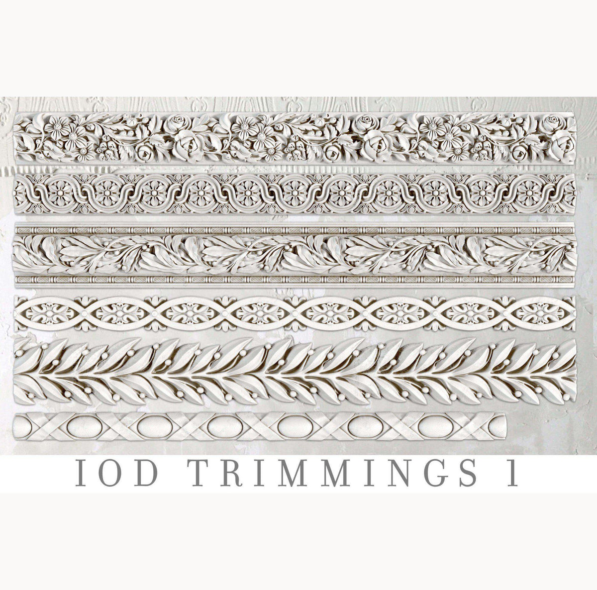 Six white trims crafted with I.O.D. Trimmings 1 Mould and air dry clay, arranged side by side.