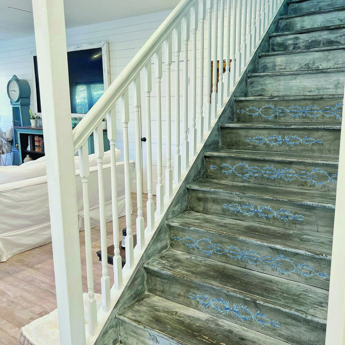 Wooden stairs featuring I.O.D. Trompe L’oeil Bleu Paint Inlay; white upcycled furniture in background.