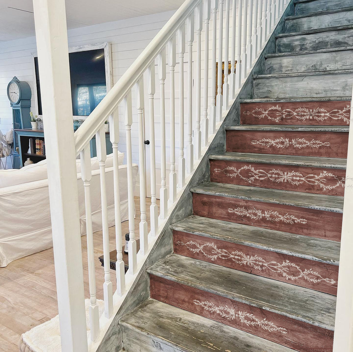 Wooden stairs with I.O.D. Trompe L’oeil Laurel Paint Inlay risers and white spindles.