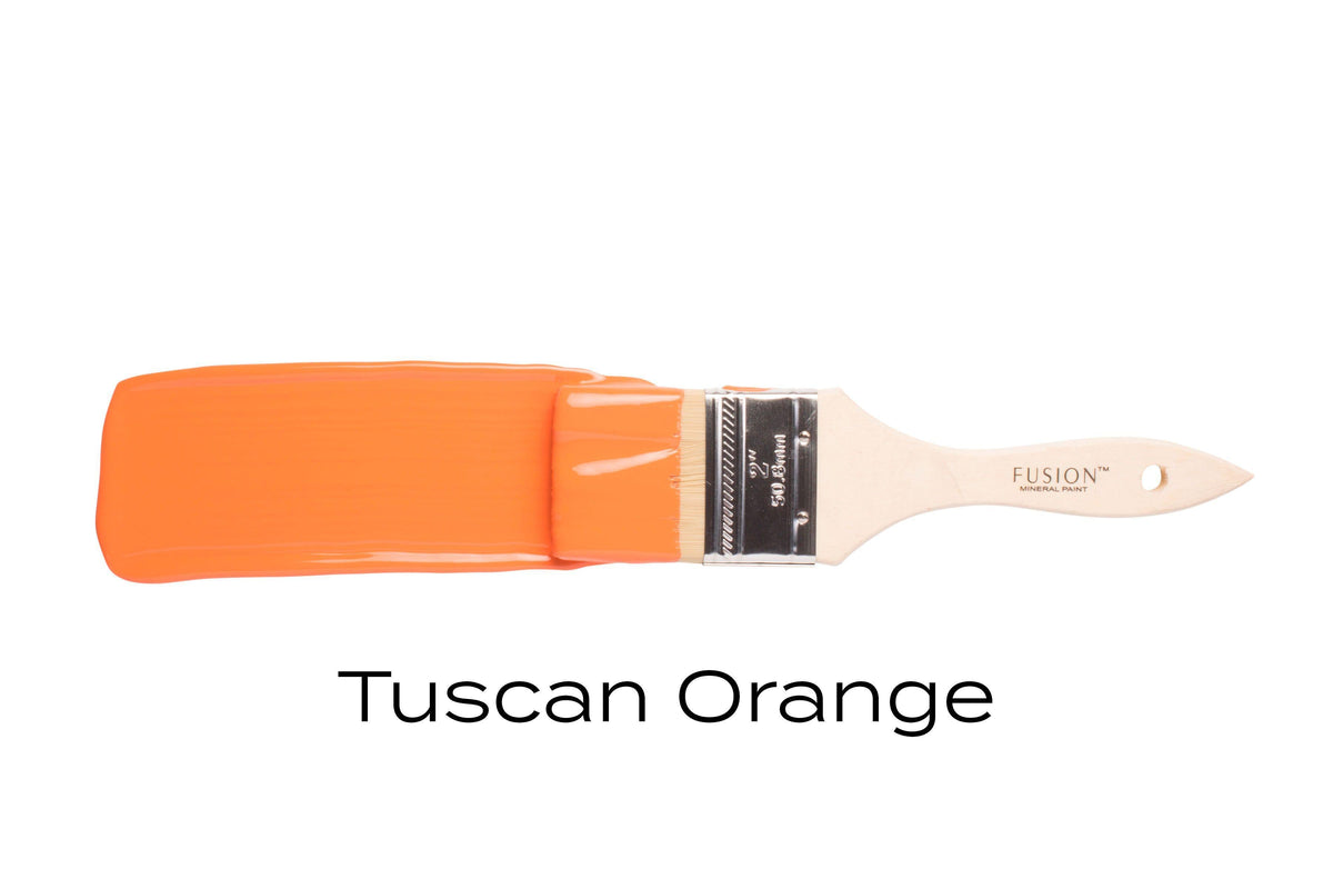 Paintbrush coated with Fusion Mineral Paint Tuscan Orange (Seasonal) on a plain white background.