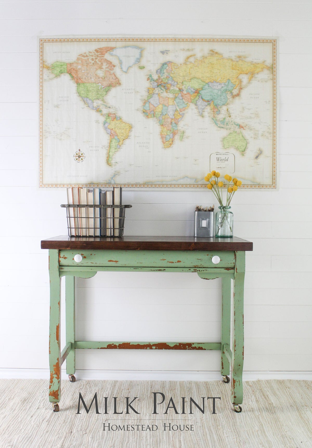 Green table painted in Homestead House Upper Canada Green Milk Paint with books and flowers on top.